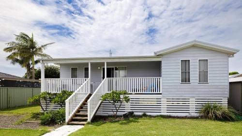 a white house with a white fence at 2B at Swansea cosy cottage, outdoor pet friendly in Swansea