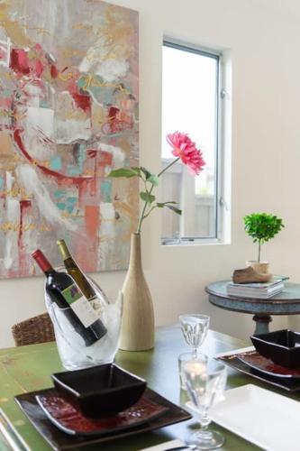 a table with a vase with a flower and wine bottles at Costa Mesa Cozy Retreat, Modern and Smart Home in Costa Mesa