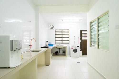 a white kitchen with a sink and a microwave at Sweet 9ight Menglembu Falim Homestay in Ipoh
