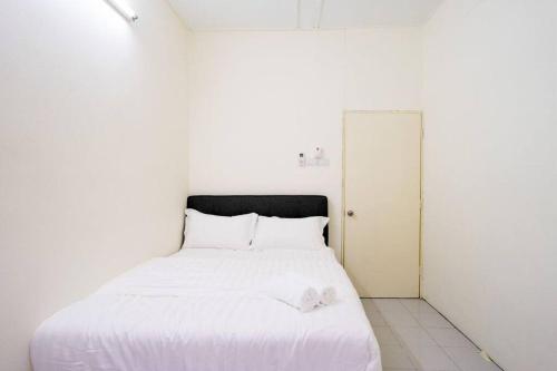 a bedroom with a white bed with white sheets at Sweet 9ight Menglembu Falim Homestay in Ipoh