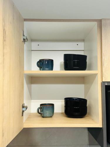 a shelf with three cups sitting on it at PrimVilla Apartment in Gaborone