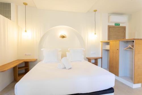 a bedroom with a large white bed with two pillows at Reina Victoria El Mercado in Alicante
