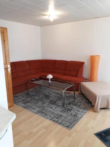a living room with a red couch and a table at Zum Harzblick in Seesen