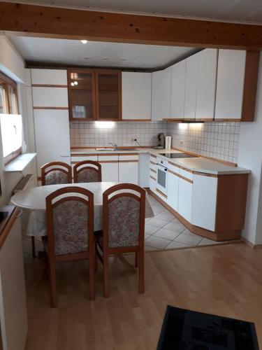 a kitchen with a table and chairs and a kitchen with white cabinets at Zum Harzblick in Seesen