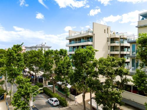 an apartment building with a parking lot and trees at Hotel Cristallo in Rimini