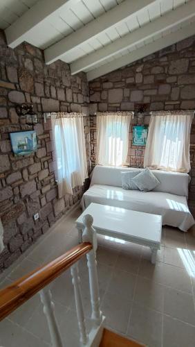 a bedroom with two beds and a stone wall at Lesvos Tower House Komninos in Sígrion