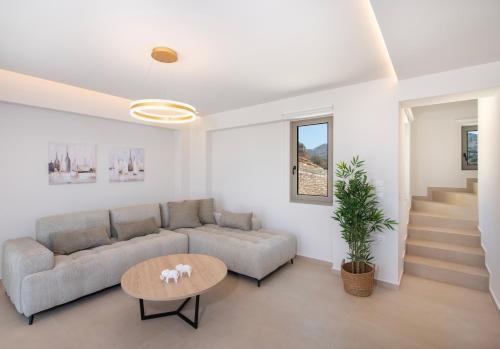 a living room with a couch and a table at Calmo Luxury Villas, with Pool Tranquil Elegance, By ThinkVilla in Lamerianá