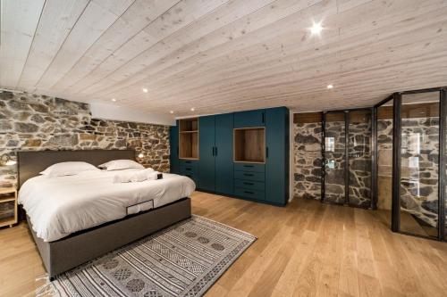 une chambre avec un lit et un mur en pierre dans l'établissement Le duplex des pentes AIL, à Lyon