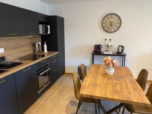 une cuisine avec une table, des chaises et une horloge murale dans l'établissement Le Bellevue, à Nancy