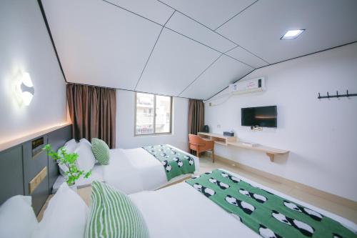 a hotel room with two beds and a tv at 莆田市湄洲岛蓝湾半岛宾馆妈祖祖庙店 in Putian