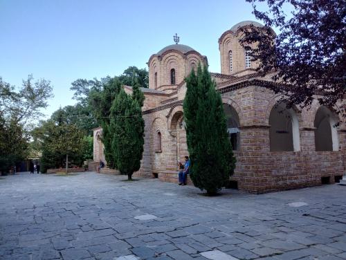 an old brick church with two trees in front of it at Villa Olympia in Paralia Katerinis