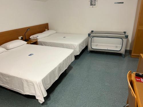a hospital room with two beds and a tv at Residencia Mediterraneo in San Vicente del Raspeig