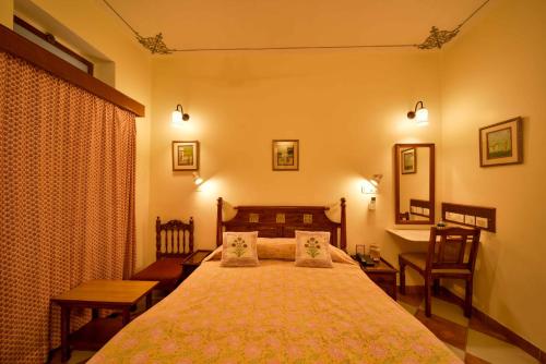 a bedroom with a bed and a table and a desk at Hotel Arya Niwas in Jaipur