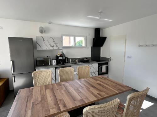 une cuisine avec une table en bois et quelques chaises dans l'établissement Maison 30 avec 5 chambres lechaffardcom, à Satolas-et-Bonce