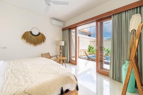 a bedroom with a bed and a balcony at Kubung 2 - NEW listing Promo - Canggu - Big Pool and Kitchen in Kerobokan