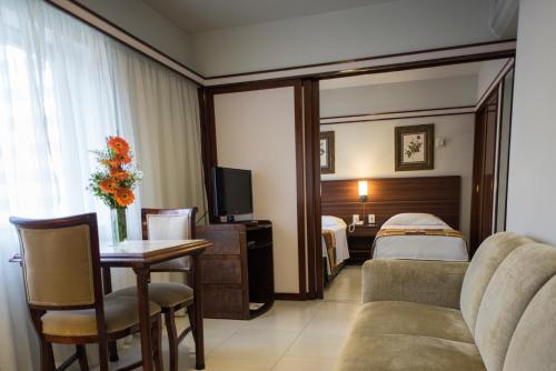 a hotel room with a bed and a couch and a table at Bristol The Time Berrini in Sao Paulo