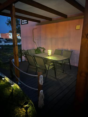 a table and chairs on a deck at night at Perland Vacation in Sidari