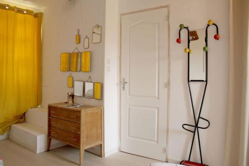 La salle de bains est pourvue d'une porte blanche et d'une commode en bois. dans l'établissement Charmante maison de village verdon, à Baudinard