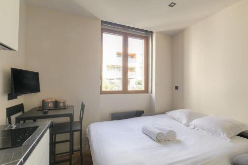 une chambre avec un lit et un bureau avec un ordinateur portable dans l'établissement Studio confortable près de la Croix-Rousse, à Caluire-et-Cuire