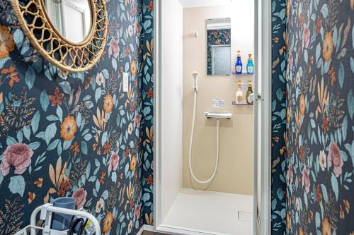 a bathroom with a shower with a floral wallpaper at GlampDome Shimonoseki in Maeda
