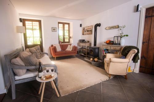a living room with two chairs and a stove at Le Souvenir in Lenax