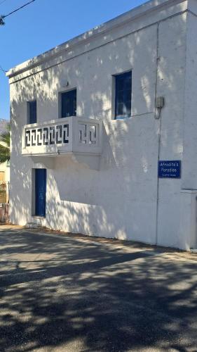 a white building with a balcony on the side of it at Ο Παράδεισος της Αφροδίτης in Kalymnos