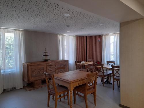 Un comedor con mesa y sillas y ventanas. en Les pierres roses, en Coise