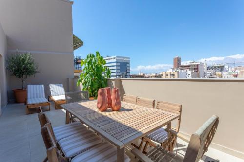 a wooden table and chairs on a balcony at Reina Victoria El Mercado in Alicante