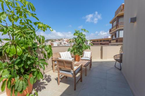 a patio with chairs and plants on a balcony at Reina Victoria El Mercado in Alicante
