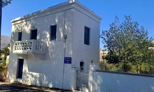 a white building with a balcony and a fence at Ο Παράδεισος της Αφροδίτης in Kalymnos