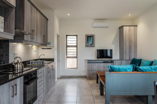 a kitchen with wooden cabinets and blue pillows at ATKV Goudini Spa in Rawsonville