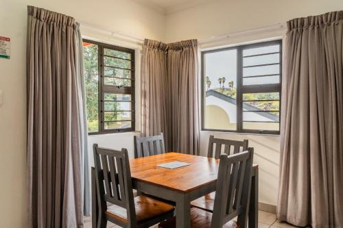 a dining room with a table and chairs and a window at ATKV Goudini Spa in Rawsonville