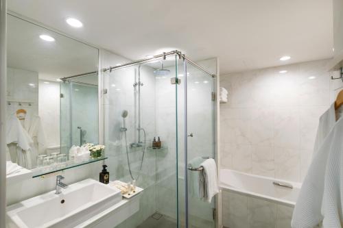 a bathroom with a glass shower and a sink at The Riverie by Katathani in Chiang Rai