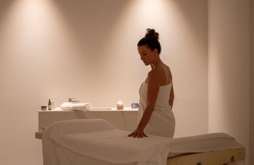 a woman standing next to a bed in a bathroom at Bluesun Hotel Marina in Brela