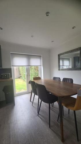 a dining room with a wooden table and chairs at Freshen - up Stays Birmingham Spacious 3-Bed Contractor & Insurance Accommodation Parking Garden in Birmingham