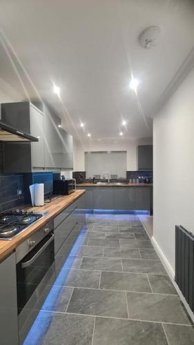 a large kitchen with a tile floor in a room at Freshen - up Stays Birmingham Spacious 3-Bed Contractor & Insurance Accommodation Parking Garden in Birmingham