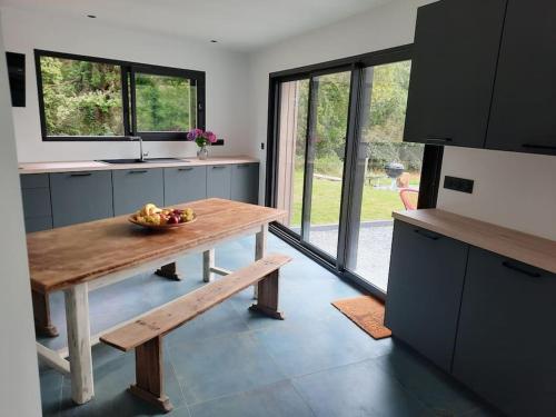 une cuisine avec une table avec un bol de fruits dessus dans l'établissement Charmante maison au cœur de la forêt, à Baguer-Morvan