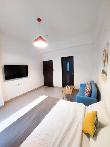a room with a bed and a couch and a tv at 雀居民宿 in Yuli