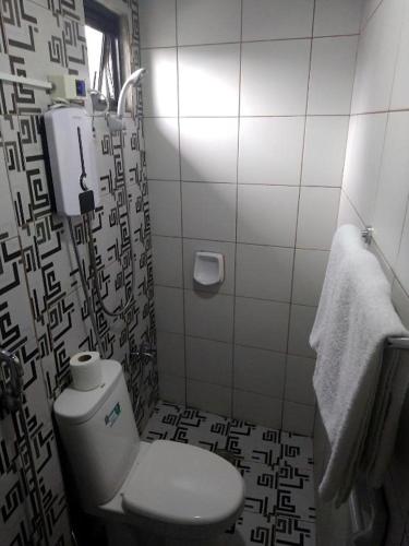 a bathroom with a toilet and a shower curtain at Jil's Apartelle in Tagaytay