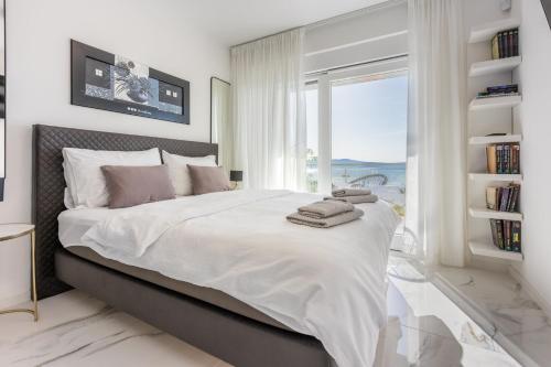 une chambre blanche avec un grand lit avec une fenêtre dans l'établissement Kuca Nena, à Crikvenica