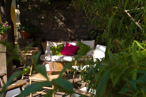 a couch with two pillows on it in a garden at B&B La Porticella in Viterbo