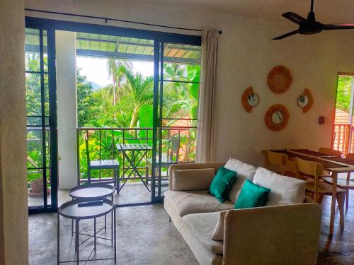 a living room with a couch and a table at Koh Tao -Tropical Apartments in Koh Tao
