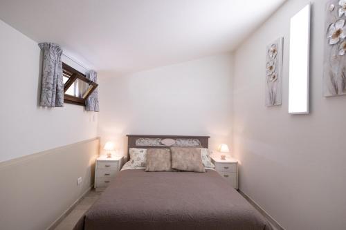 a bedroom with a bed with two night stands and two lamps at Di Colle in Colle - Agriturismo in Passignano sul Trasimeno