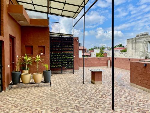 a patio with potted plants and a bench on a building at Firebrick Boutique Residences - GARNET HOUSE in Gurgaon