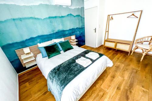 a bedroom with a large bed with a painting on the wall at AC - Secure Parking - Near Central Station in Avignon