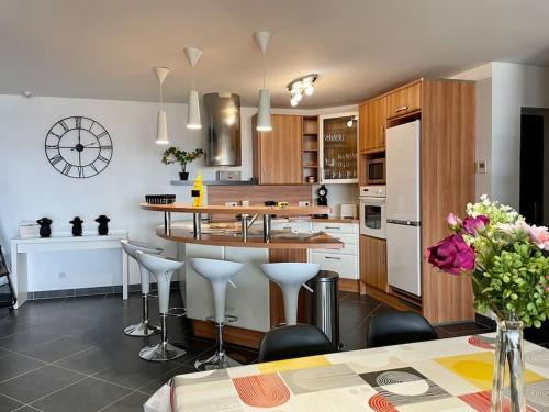 une cuisine avec un îlot et des tabourets de bar dans l'établissement Amfreville la Mivoie - le Belvédère de Rouen, à Amfreville-la-Mi-Voie