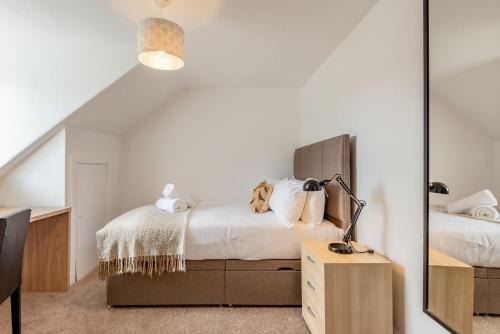 a bedroom with two beds and a mirror at Kinness Place - No 6 in St. Andrews