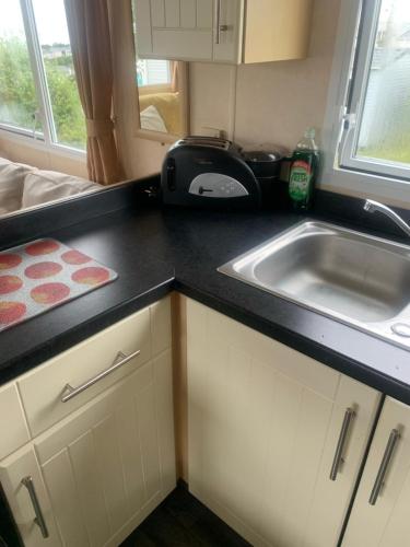 a kitchen counter with a sink and a toaster at Haven Devon Cliffs Caravan in Budleigh Salterton