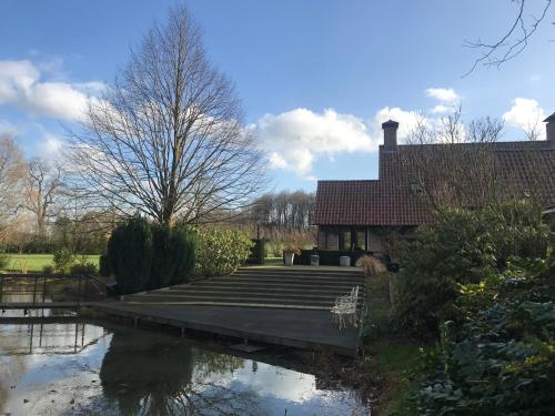 a house with a dock next to a body of water at Moderne Studio's Twente in Markelo