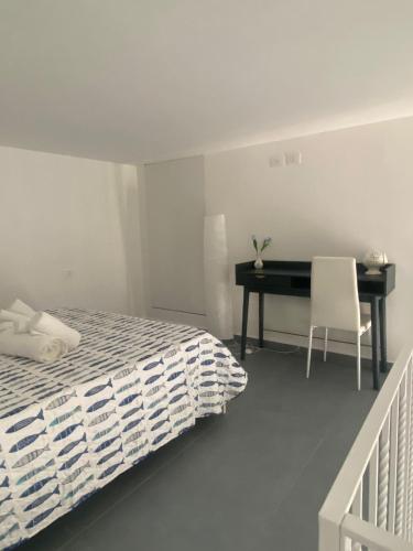 a bedroom with a bed and a desk with a chair at Casa n'to strittu in Lipari